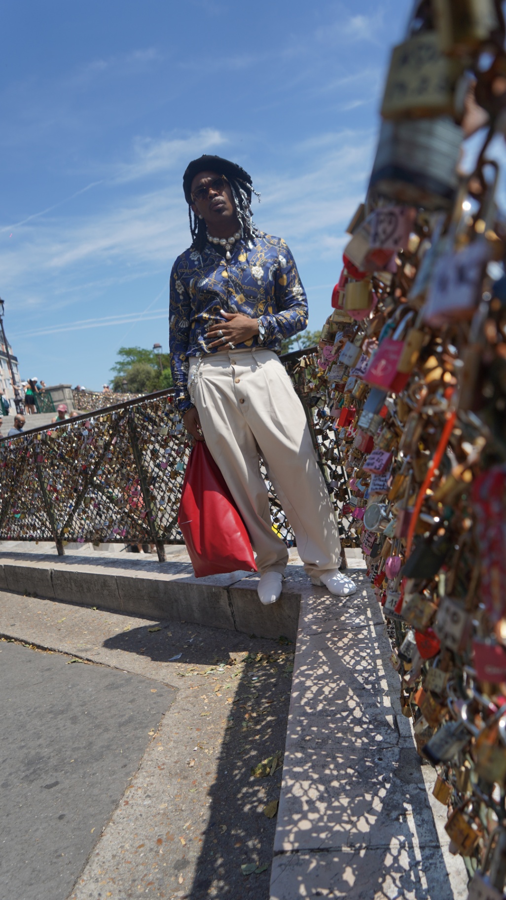 FYRE. wide shot on the love-lock bridge, red bag